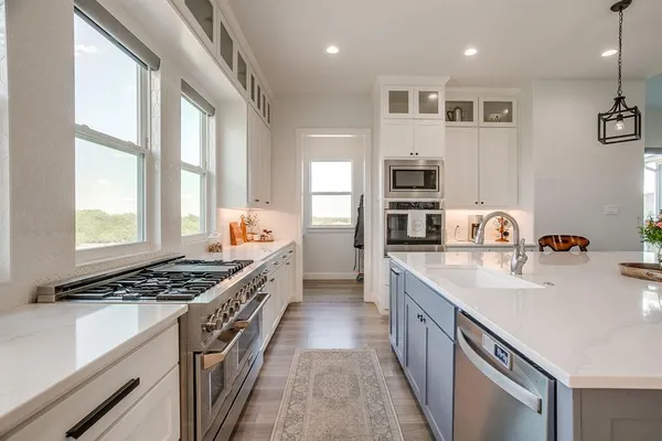 a kitchen with kitchen island stainless steel appliances a sink stove and refrigerator