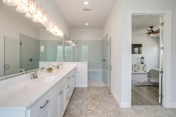 a spacious bathroom with a double vanity sink a mirror and shower