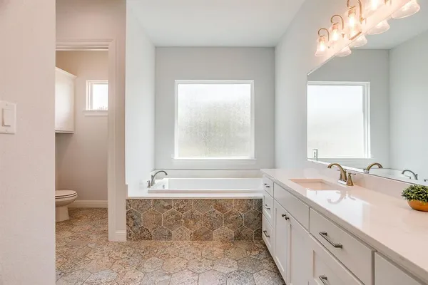 a bathroom with a tub sink and mirror