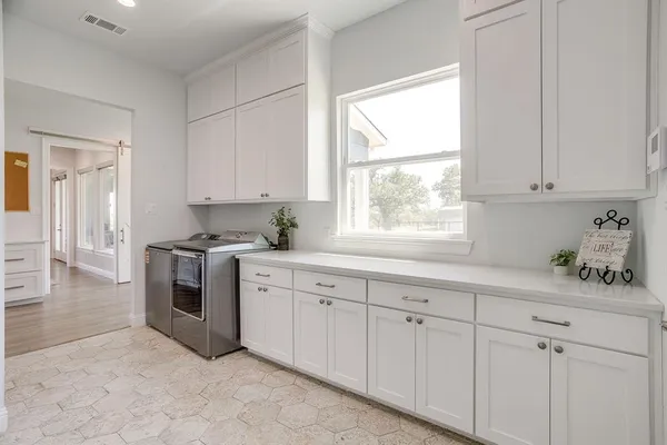 a kitchen with white cabinets and white appliances