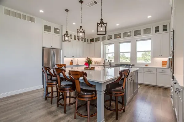 a view of a dining room and livingroom with furniture wooden floor a chandelier