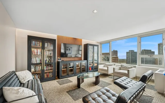 a living room with furniture and a floor to ceiling window