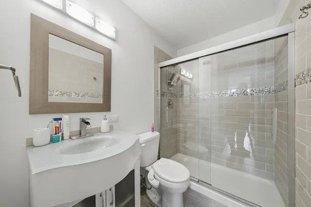 a bathroom with a sink toilet and shower