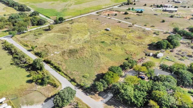 a view of a dry yard with wooden fence