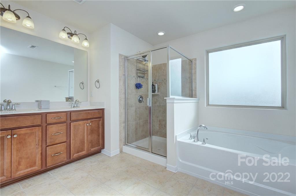 7006 Swamp Chestnut Lane Indian Land, SC 29707 - Photo 17 of 25 a spacious bathroom with a tub sink shower and mirror