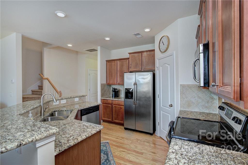 7006 Swamp Chestnut Lane Indian Land, SC 29707 - Photo 6 of 25 a kitchen with stainless steel appliances granite countertop a sink a stove and a refrigerator