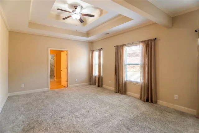 an empty room with closet and a ceiling fan