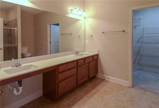 a spacious bathroom with a granite countertop sink and a mirror