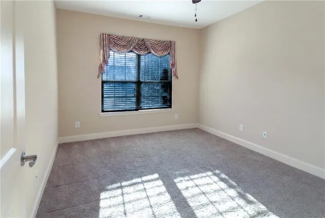 an empty room with windows and mirror