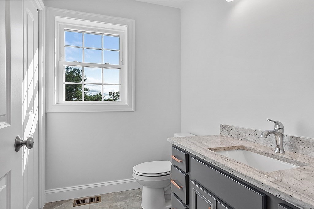 8 Worcester Road, Unit LOT 1 Westminster, MA 01473 - Photo 18 of 38 a bathroom with a granite countertop toilet a sink and a window