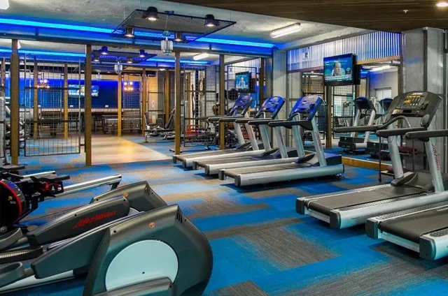 a view of gym equipment with wooden floor