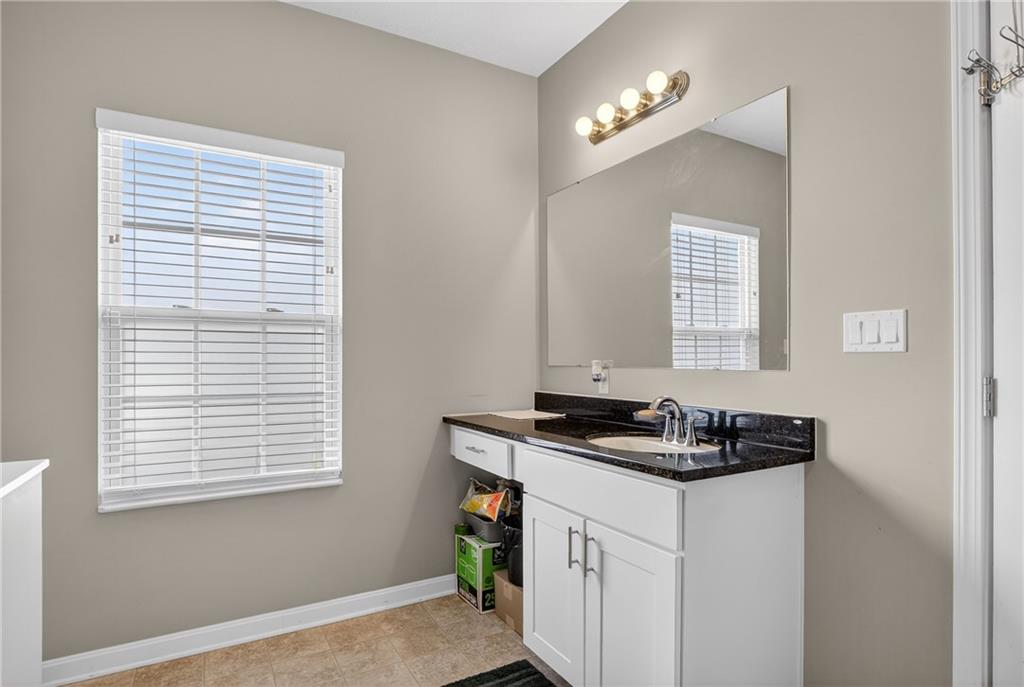 423 Labrador Lane Clairton, PA 15025 - Photo 25 of 49 a bathroom with a granite countertop sink a vanity and a window