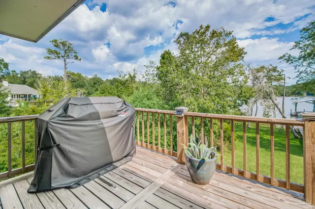 a view of a balcony with wooden floor and iron fence