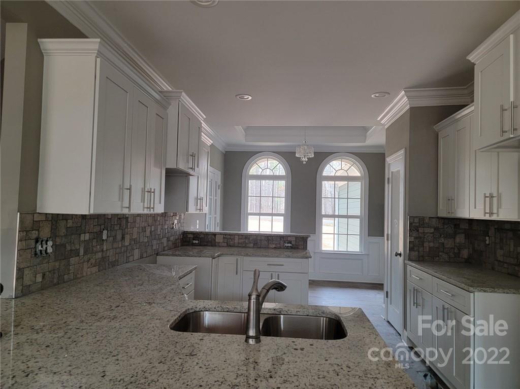1152 Blacksnake Road Stanley, NC 28164 - Photo 6 of 15 a kitchen with granite countertop a sink a stove and cabinets