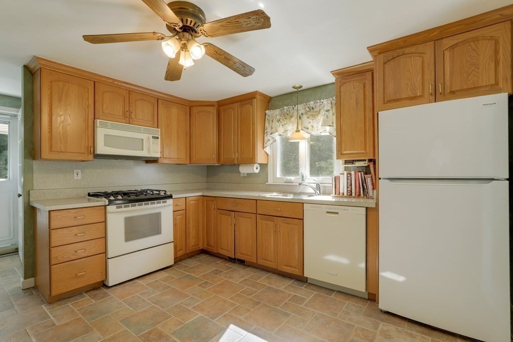 a kitchen with stainless steel appliances granite countertop a refrigerator a stove a sink and dishwasher with wooden floor