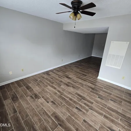a view of a room with a ceiling fan and wooden floor