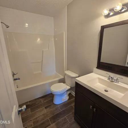 a bathroom with a sink toilet vanity and shower
