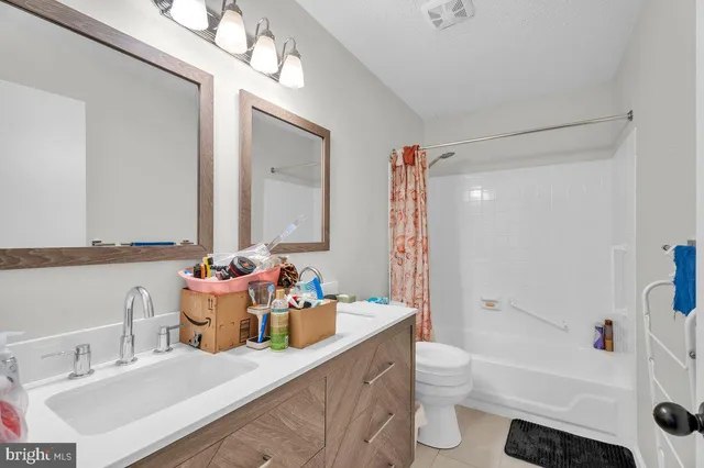 a bathroom with a granite countertop sink a toilet and a bathtub