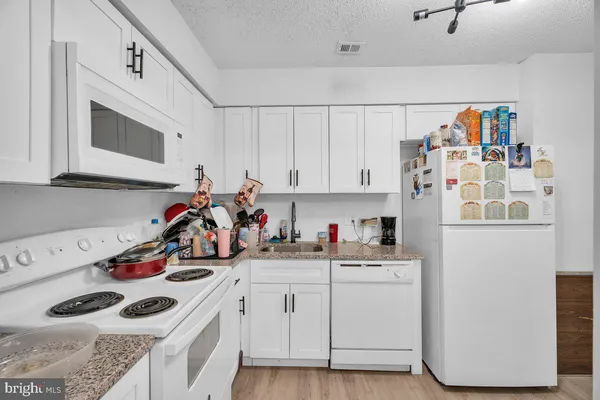 a view of a kitchen with sink and white cabinets