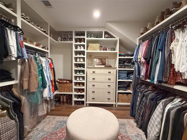 a view of walk in closet with clothes and shoes