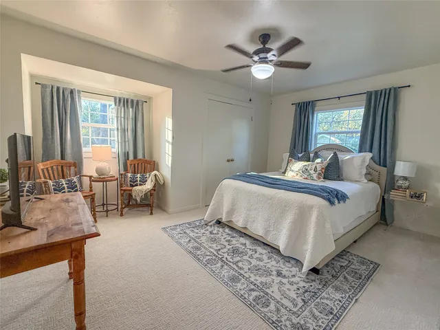 a bedroom with bed and a large window