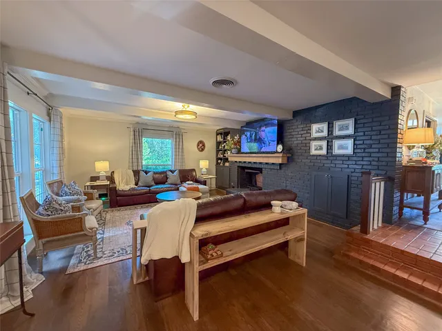 a living room with furniture a fireplace and a flat screen tv