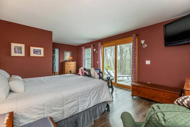 a bedroom with a bed window and a flat screen tv