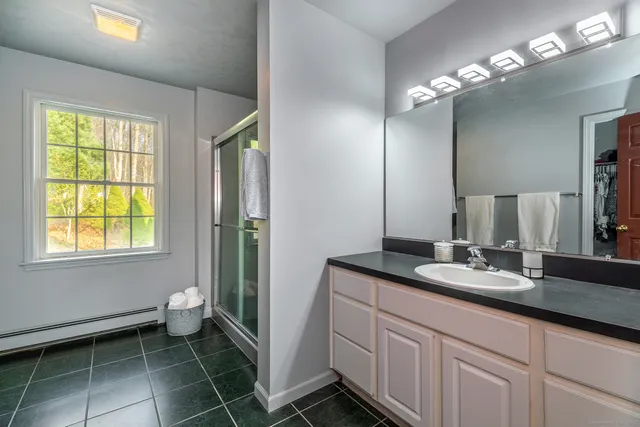 a bathroom with a granite countertop sink a toilet and a mirror
