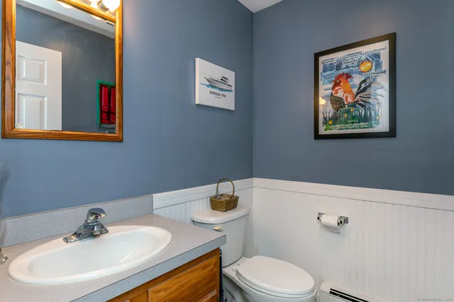 a bathroom with a toilet a sink and mirror