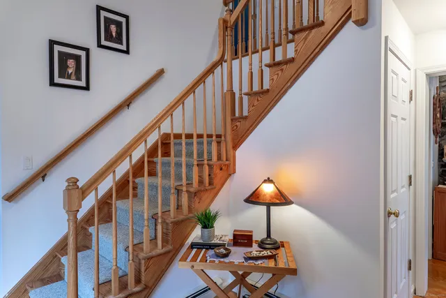a view of staircase with furniture and a lamp