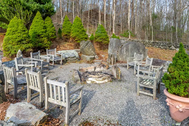 a view of a backyard with chairs and potted plants