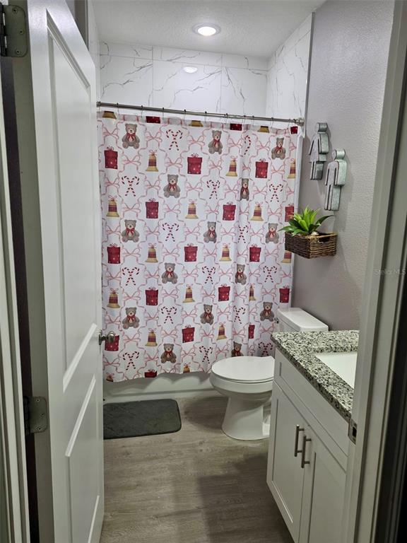 697 James Court Kissimmee, FL 34759 - Photo 7 of 17 a bathroom with a granite countertop sink a toilet and shower curtain