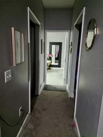 a view of a hallway with wooden floor and cabinets