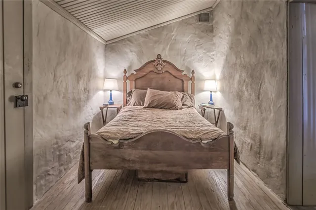 a bedroom with a bed and wooden floor