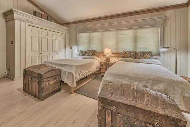 a spacious bedroom with two beds and a large window