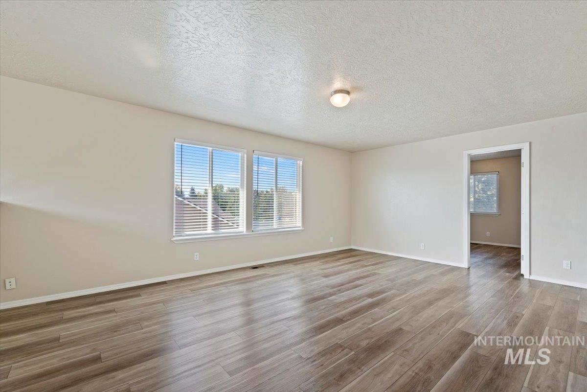 994 North Gray Cloud Way Meridian, ID 83642 - Photo 14 of 28 Spare room featuring a textured ceiling and light wood-style floors