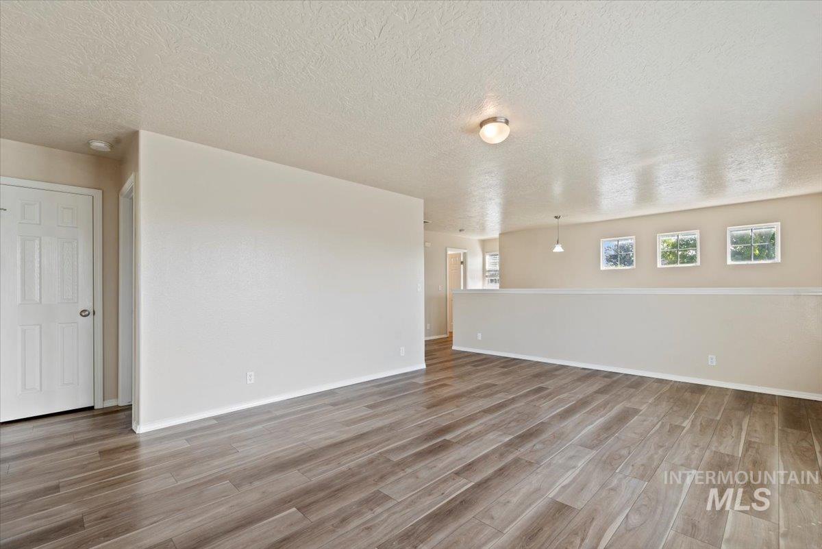 994 North Gray Cloud Way Meridian, ID 83642 - Photo 15 of 28 Unfurnished room featuring a textured ceiling and light wood-style flooring