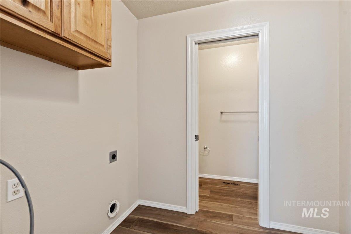 994 North Gray Cloud Way Meridian, ID 83642 - Photo 25 of 28 Laundry room with hookup for an electric dryer, dark wood-style flooring, and cabinet space