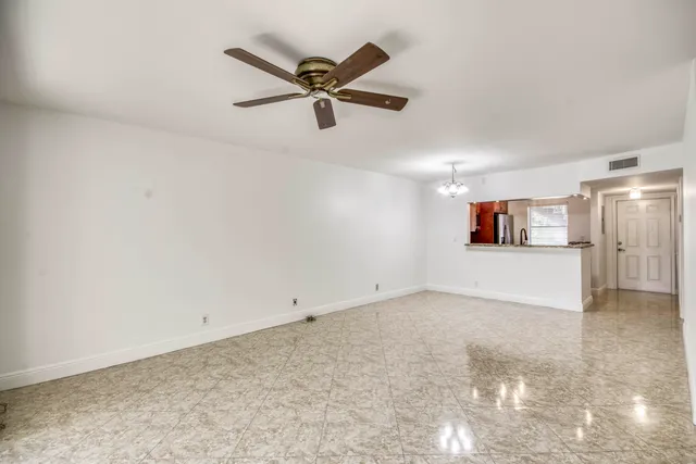 a view of a big room with wooden floor and windows