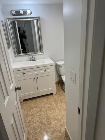 a bathroom with a sink a toilet and mirror