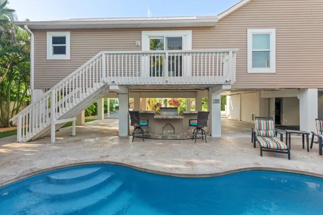a view of an empty room with wooden floor and a ceiling fan