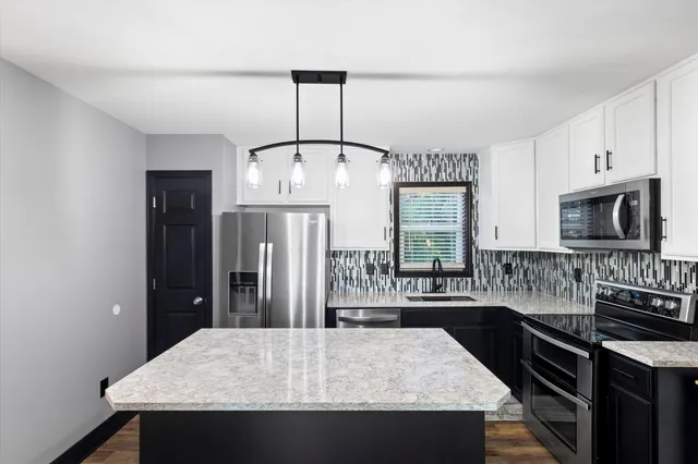 a view of a livingroom with wooden floor and stairs