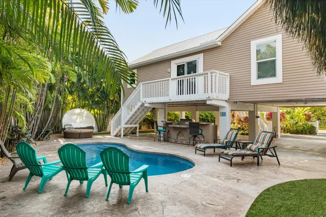 a view of a house with swimming pool and sitting area