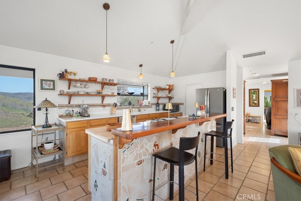 9750 Random Canyon Way Creston, CA 93432 - Photo 19 of 73 a kitchen with stainless steel appliances kitchen island granite countertop a table chairs and a refrigerator