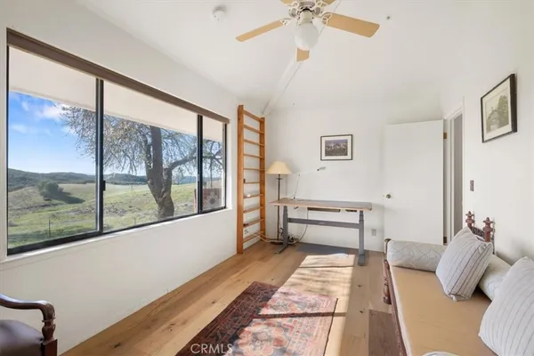 a bedroom with furniture and a large window