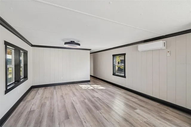 a view of a hallway with wooden floor and closet