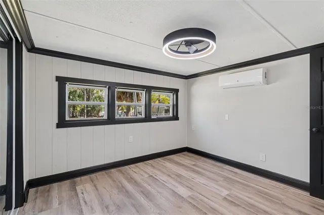 an empty room with wooden floor and window