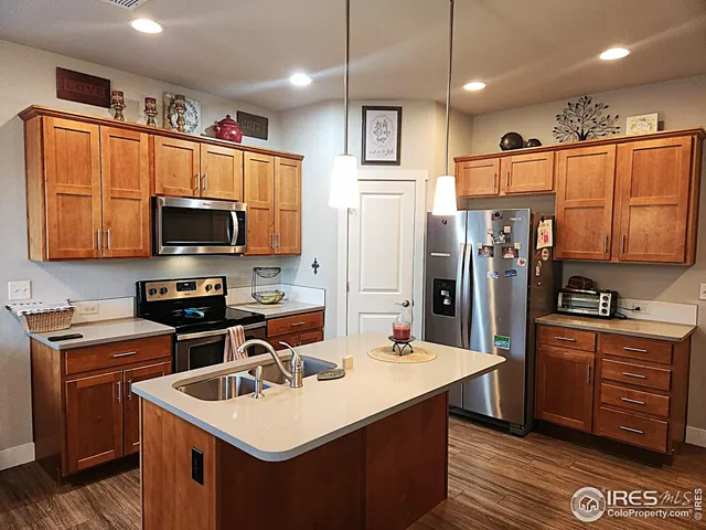 a kitchen with stainless steel appliances a stove refrigerator sink and microwave