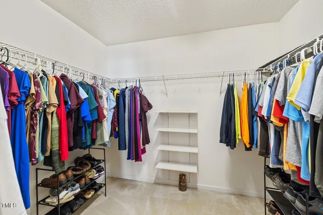 a view of walk in closet with clothes