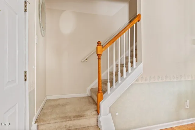 a view of staircase with lots of frames on wall and a window